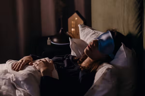 Woman resting peacefully in bed, emphasizing the importance of quality sleep for blood sugar control.