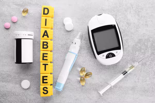 Blood glucose monitor next to the word "DIABETES", representing diabetes management and health awareness.